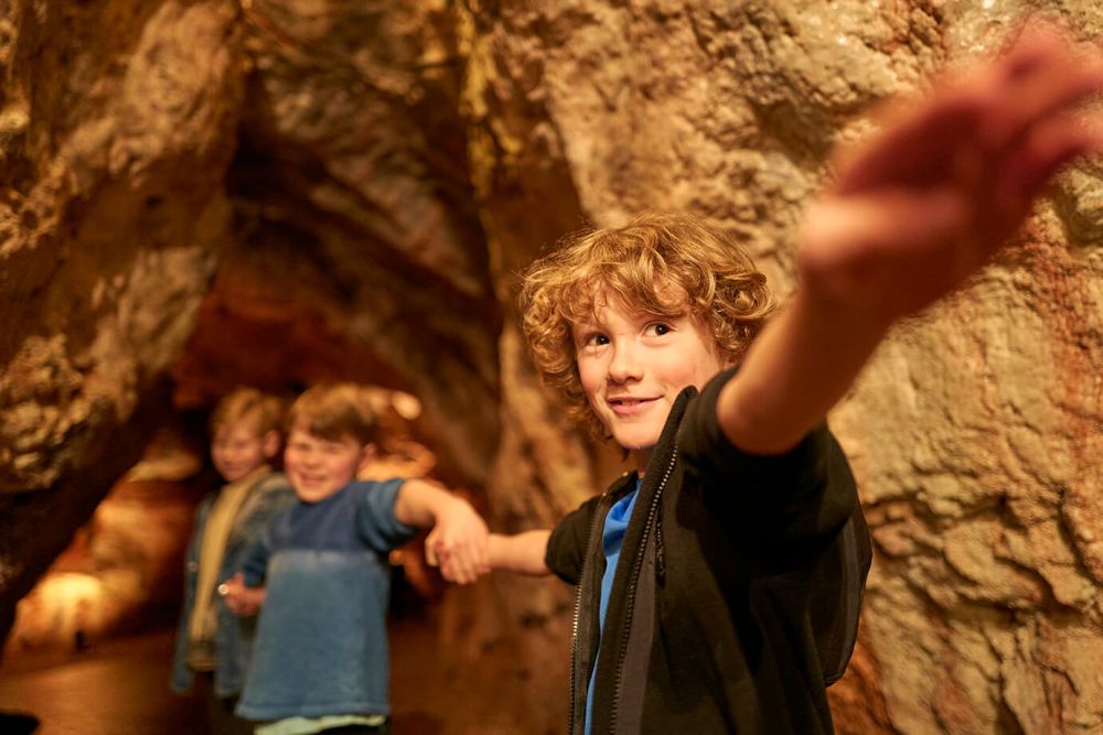 Child reaching in a cave | Kents Cavern, Torquay